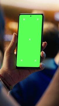 Vertical video: Close-up of isolated screen mobile phone used by soccer fan to compare match odds, cheering in stadium.