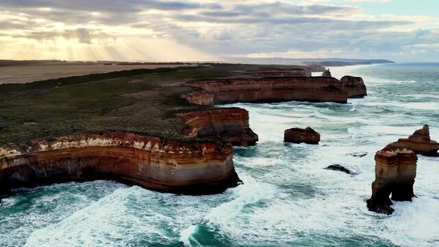 Landing in view of Twelve apostles rock formation on Australia ocean coast at sunrise.