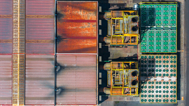 Aerial view of the Tecnovia Acores industrial facility featuring corrugated metal roofing, rusted surfaces, and rows of industrial cooling fans in Rabo de Peixe, Acores, Portugal.