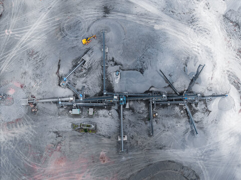 Aerial view of Tecnovia Acores quarry featuring industrial conveyor belts, heavy machinery, and piles of gravel in Rabo de Peixe, Acores, Portugal.