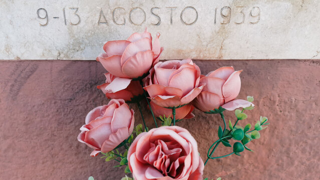 Fiori finti su monumento commemorativo rose e marmo