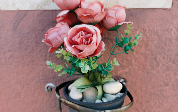 Fiori finti su monumento commemorativo rose e marmo