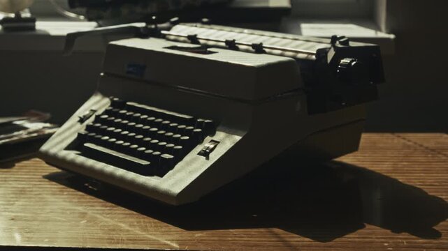 A protective cover is removed to reveal a classic typewriter waiting to be used. Symbolizes creativity, storytelling, craftsmanship, and a return to focused analog writing.