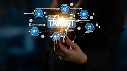 Fototapeta premium A business professional explores the concept of innovation with a light bulb, showcasing elements like target achievement and mission focus in a modern office environment. Tessel