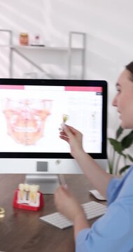 Doctor consulting woman regarding dental implantation at desk in clinic,