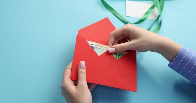 Bonus. Woman opening envelope with euro banknotes on light blue background, closeup