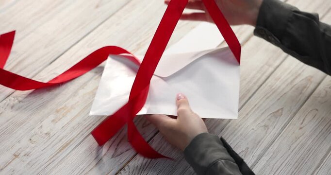 Bonus. Woman opening envelope with dollar banknotes and blank card at color wooden table, closeup