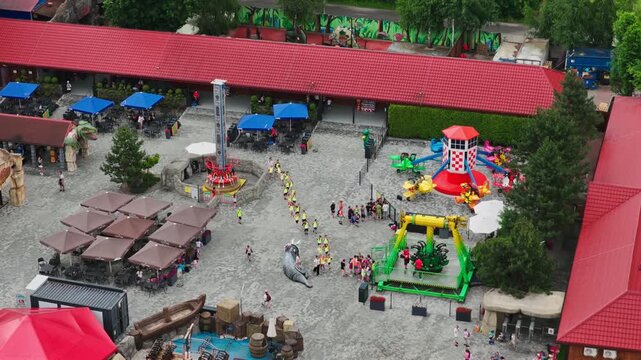 Students Walking In Queue In Energylandia Amusement Park Near Colorful Rides And Attractions During A School Trip. - aerial shot