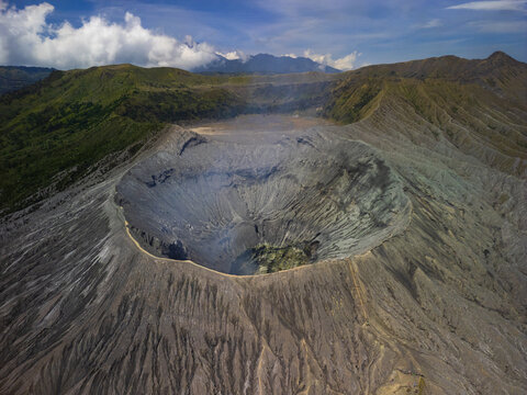 Aerial view of the volcanic crater of Mount Bromo in Bromo Tengger Semeru National Park with rugged slopes and steam rising from the caldera in Probolinggo, East Java, Indonesia.