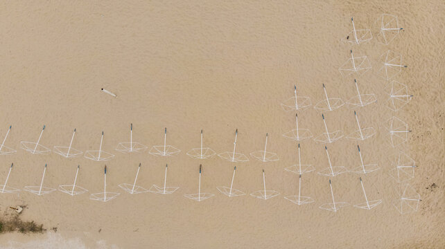 Aerial view of rows of empty beach umbrellas on the sandy shore in Varna, Varna, Bulgaria.