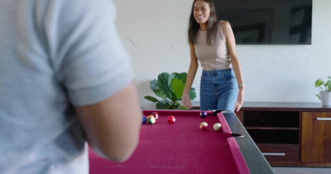 African American couple playing red felt home pool table, man breaking balls, teaching cue grip