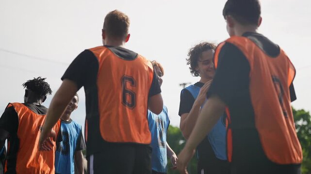 Young football teams exchange respectful handshakes before training and competition on an outdoor field. Dedicated coaches guide players as they develop teamwork, sportsmanship, technical skills,.