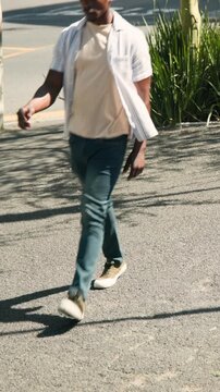 Vertical video: Entering from right, man in open shirt walking past sidewalk railing and pink bike