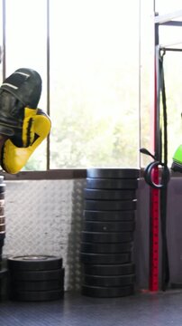 Vertical video: Boxing boxer with gloves teal shorts drilling at gym trainer entering with mitts