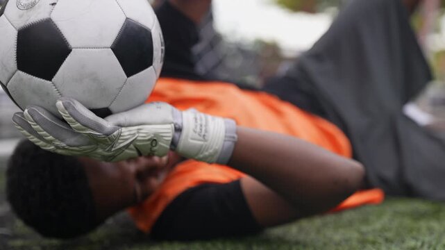 Professional football goalkeeper demonstrates outstanding athletic ability while preparing to stop an incoming shot during outdoor practice. Strong reflexes, confidence, agility, technical excellence,