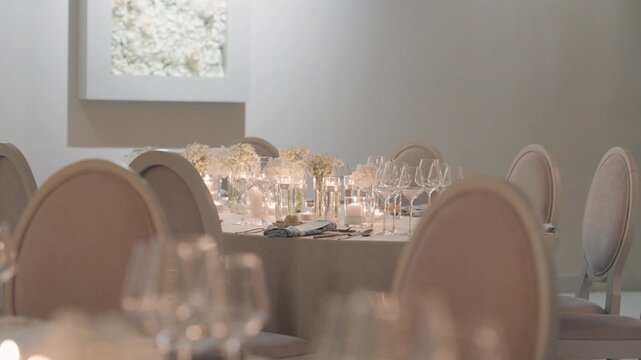 Luxurious banquet table arrangement featuring minimalist white floral centerpieces, crystal glassware, and warm candlelight for an authentic wedding celebration.