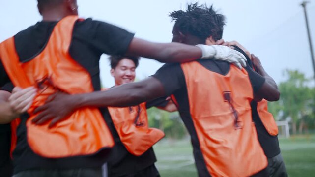 Soccer teammates celebrate triumph after scoring a penalty, hugging and cheering enthusiastically while disappointed opponents accept the result, emphasizing teamwork, perseverance, achievement, sport