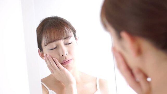 お肌のチェックをして残念がる日本人女性