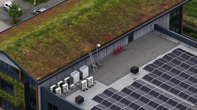 Aerial view of a modern office building featuring a lush sedum roof, solar panels for renewable energy, multiple air conditioning units, and a living wall, showcasing sustainable architecture