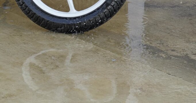 Showcasing rainwater splashing a tire urban street wet environment nature in motion. Perfect for projects highlighting transportation themes, modern lifestyles, and authentic environments.