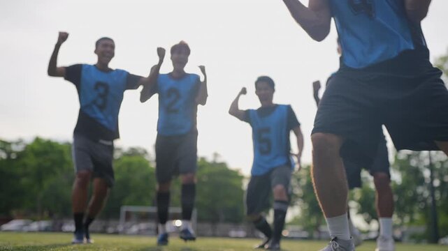 Football teammates joyfully celebrate a crucial penalty goal, jumping together in excitement while opposing players display disappointment, riendship, teamwork, passion in sports.