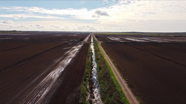 Flying backward reveals flooded peat fields across the Rucava countryside