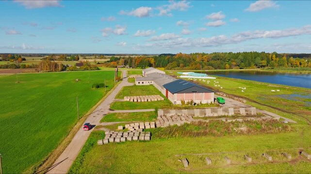 Following red vehicle drone reveals farm and ongoing field operations, Latvia