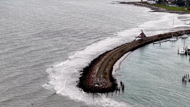 Aerial drone view of the curved breakwater protecting Eg&aring; Marina along the coastline of Aarhus Bay in Denmark.