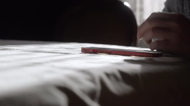 A calm, aesthetic close-up of a person texting on a smartphone laid flat on a table as soft morning sunlight sweeps across. Ideal for clean lifestyle, communication, and modern narrative projects.