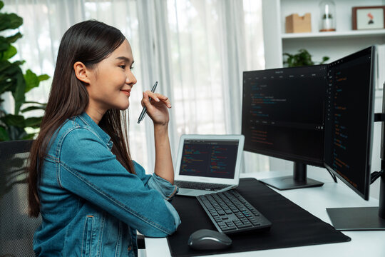 Young Asian IT developer looking online information on pc for beautiful pose with coding program data of website application, wearing jeans shirt. surround by safety analysis two screens. Stratagem.