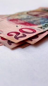Vertical 4K video. 60 fps. Woman counts Georgian cash money twenty lari on white table. 20 GEL. Stack of paper bills. Female hands and paper banknote close up. Concept of pay tax, buy, debt, salary