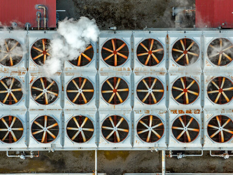 Aerial view of the Ribeira Grande Geothermal Power Station featuring rows of large industrial cooling fans with steam rising from the vents in Ribeira Grande, Acores, Portugal.