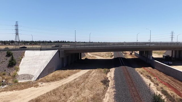 Panning Aerial Drone Shot Left to Right Revealing California High Speed Rail Construction Workers and Excavation Site With Train Track and Freeway Overpass