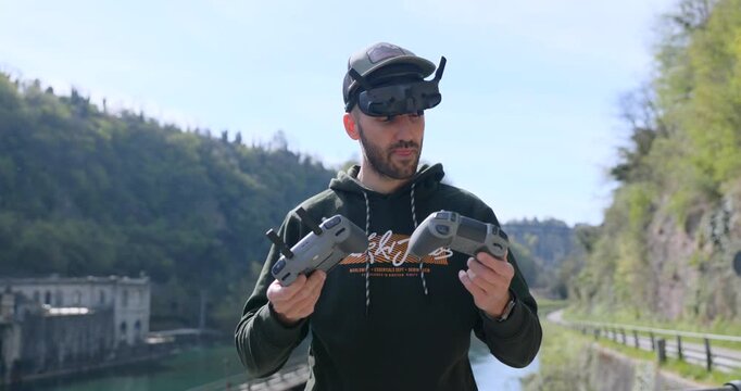 Drone operator wearing FPV goggles holding two different flight controllers