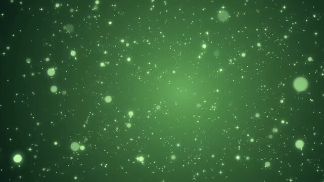 A multitude of glowing green particles and sparkling stars gently fly toward the camera. This abstract festive background with a soft bokeh effect creates a magical and mysterious atmosphere