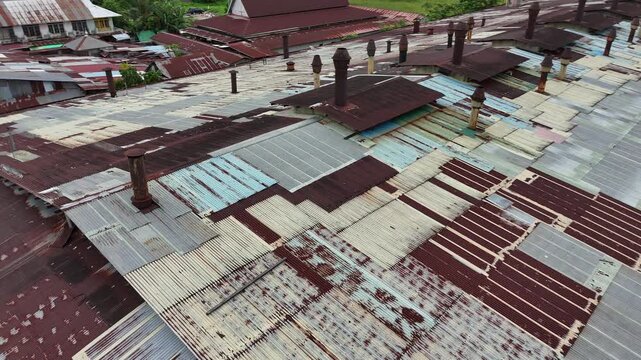 A close-up aerial view showing the factory&rsquo;s rusted corrugated metal roof with several rusted smokestacks.