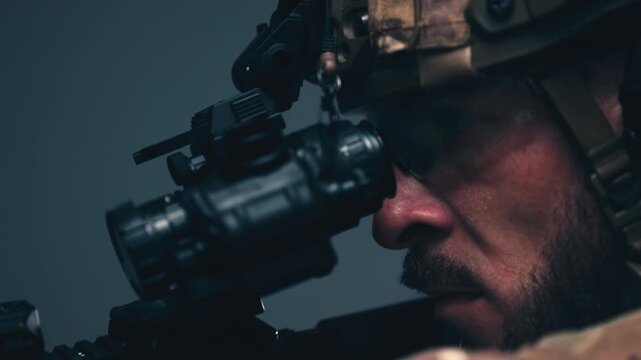 Military operator in tactical helmet aiming rifle during combat training. Concept military personnel, weapon handling and defense.
