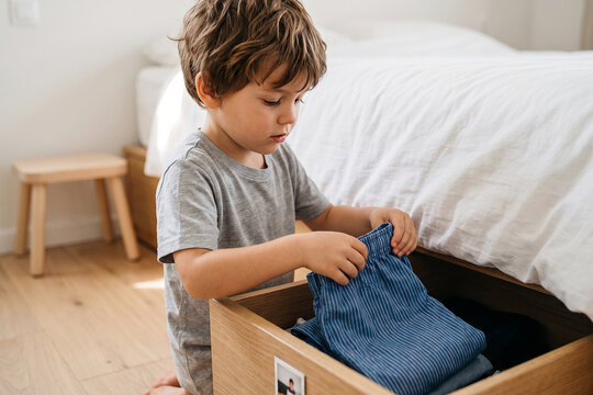 Boy Choosing Clothes from Bedroom Drawer Morning Getting Dressed