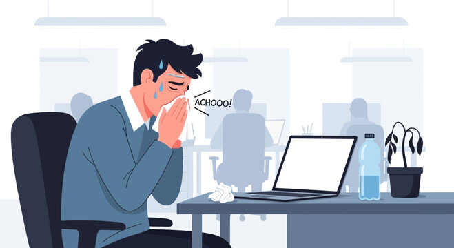 Unwell Office Worker Sneezes At His Desk Showing Signs of Sickness And Fatigue