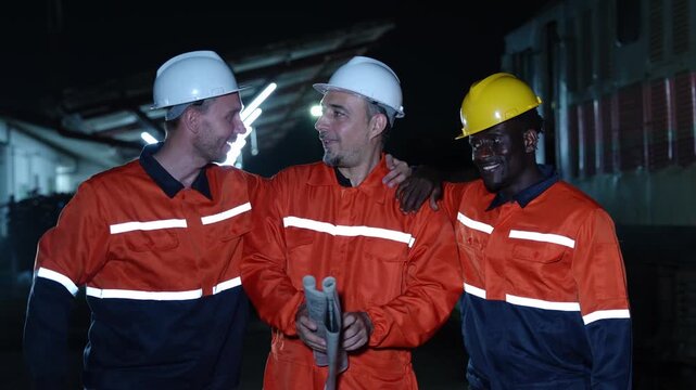 Teamwork under the stars as construction workers in safety gear collaborate on a job site during nighttime