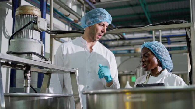 Food industry professionals collaborating in production facility for quality assurance and safety standards