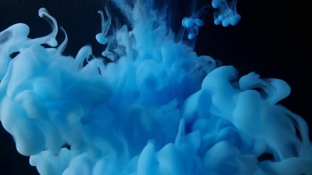 Blue ink drop cloud swirling in deep water on black background