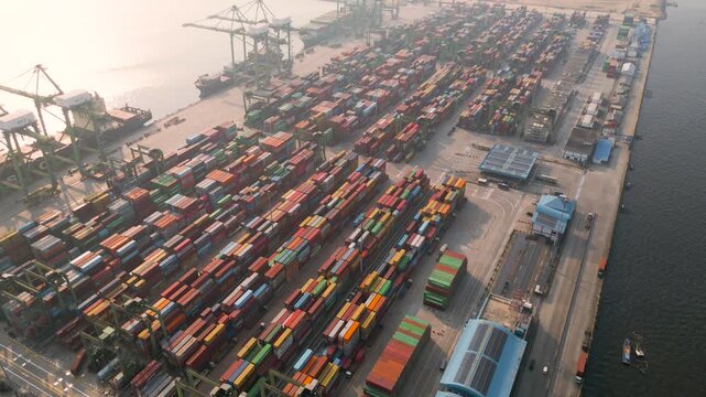 Aerial View of a Bustling Commercial Shipping Port and Container Terminal at Sunrise