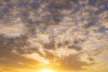 Obraz premium Golden Sunset Clouds in the Sky,A breathtaking view of the golden sunset sky filled with scattered clouds, creating a peaceful and warm atmosphere.