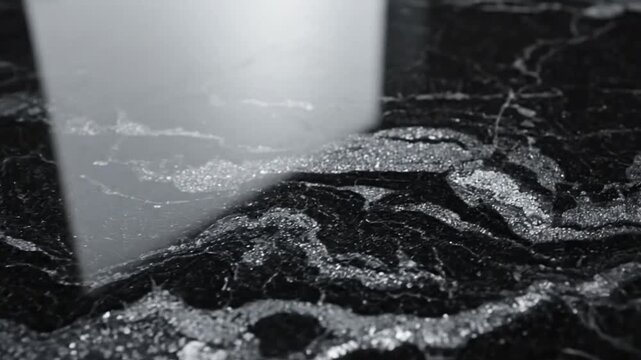 Close-up of a sparkling black and silver granite countertop with detailed texture and reflections.