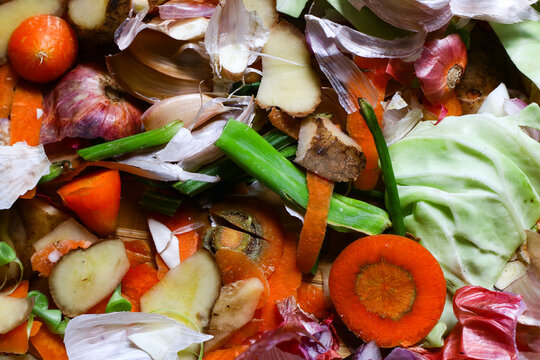 Food scraps and vegetable peels collected in a traditional bamboo tray with a kitchen knife, representing organic waste, composting, sustainable living, and eco-friendly food preparation.