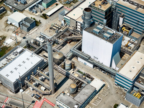 Aerial view of the Centrale Termoelettrica power plant featuring industrial buildings, tall chimneys, and complex pipe networks, Moncalieri, Piemonte, Italy.