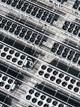 Aerial view of the EU North Riga LV DC1 data center, featuring rows of industrial cooling fans and ventilation units on the rooftop in Riga, Latvia.