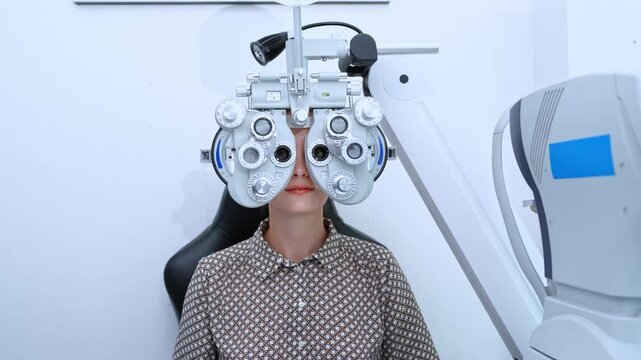 Eye care professional assessing vision using a phoropter in a contemporary clinic environment