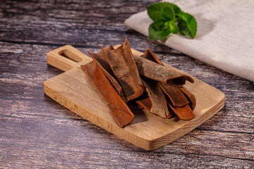 Cinnamon sticks on wooden cutting board with mint leaf © Andrei Starostin
